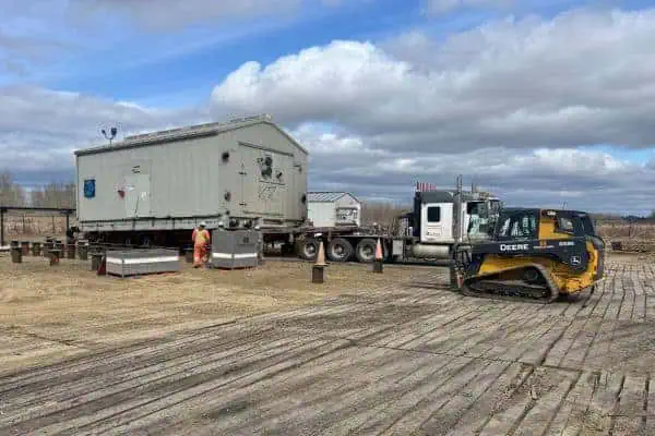 Large oilfield compressor staged on a Tundra oilfield truck and trailer ready to be relocated with Tundra Heavy Hauling and Rigging jack and roll equipment